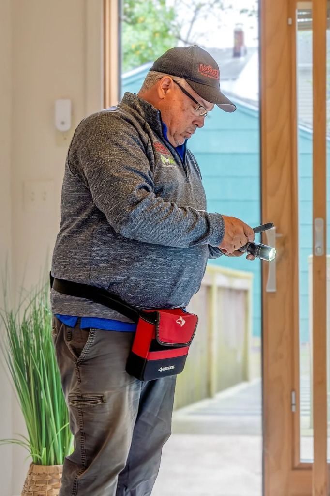 Inspector reading framing under a house